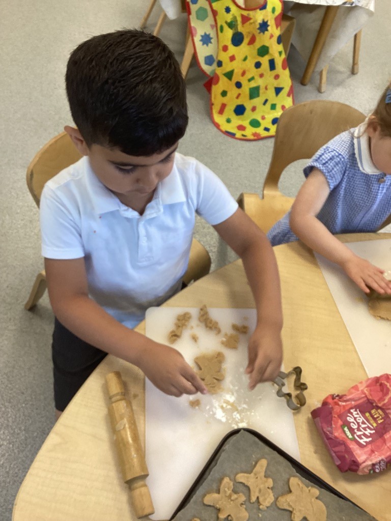 This picture shows a child using a gingerbread man cookie cutter.