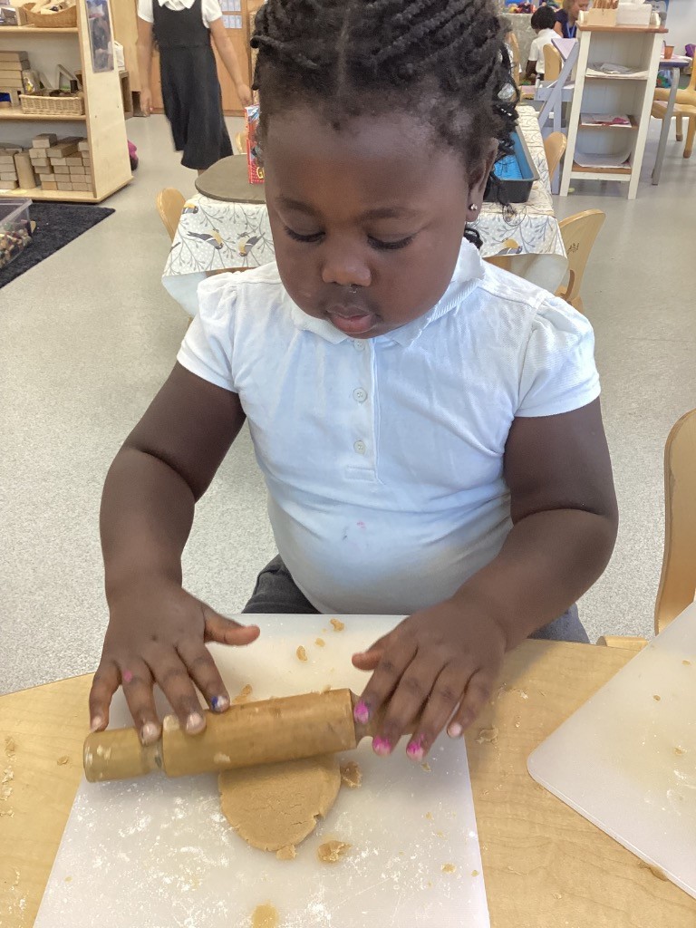 Another child focused on rolling out dough.