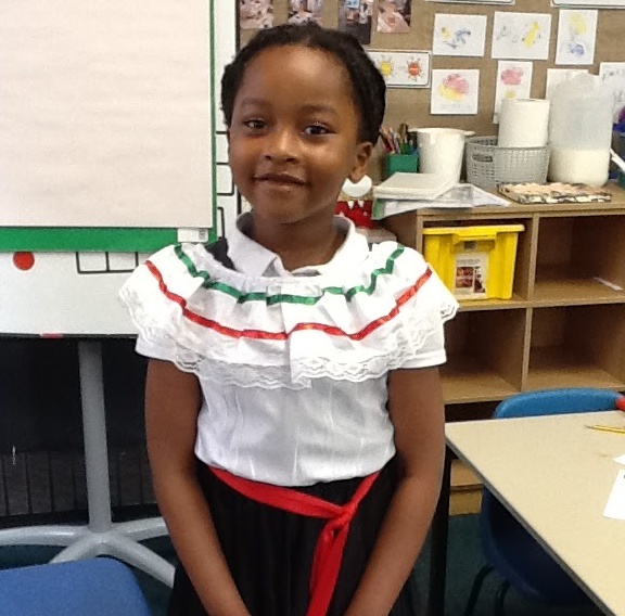 A young girl is seen smiling for the camera whilst dressed up in costume.