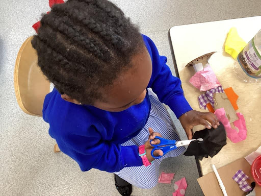 A young girl from Nursery is pictured creating his own bucket using recycled materials.