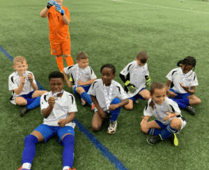 A young football team featuring girls and boys wearing medals