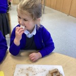 Young girl in blue school jumper eating bread