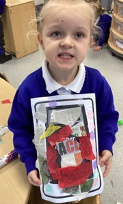 A child holds up a craft project consisting of paper scraps glued onto a printed image of a recycling bin.