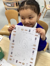 A smiling child holds up a worksheet titled "Tidy up rubbish" featuring their own drawings inside a border of recycling items